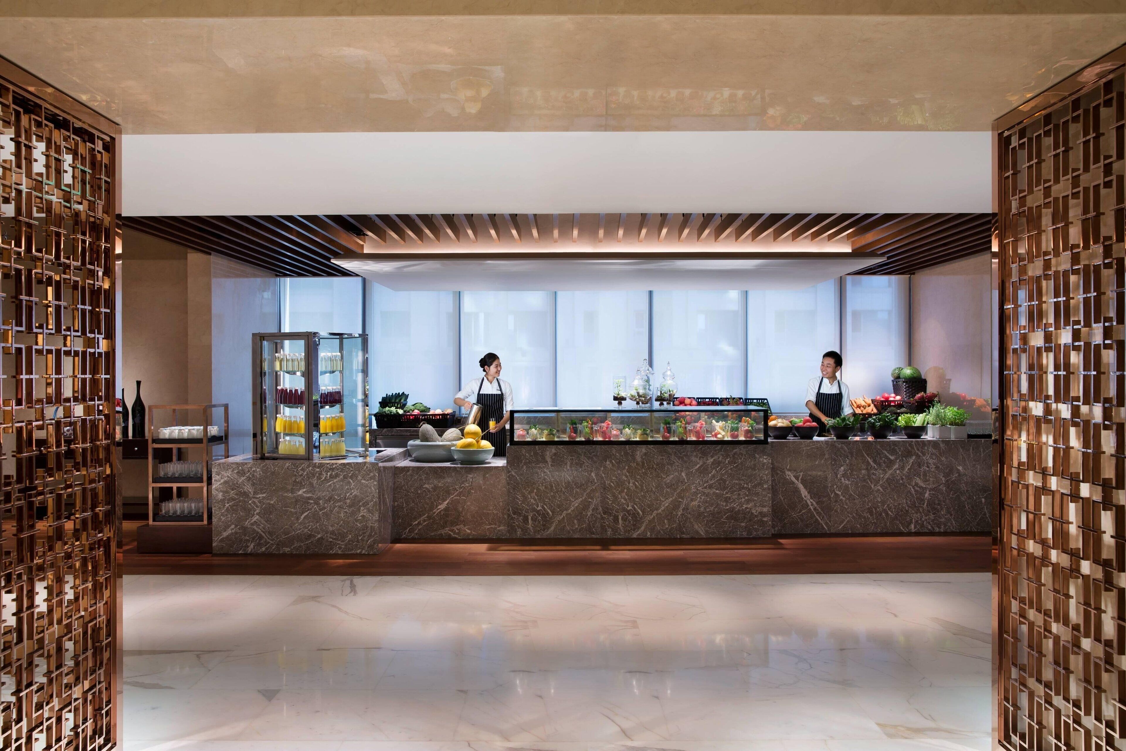 A modern reception area with marble counters, a glass display case, and wooden decor.