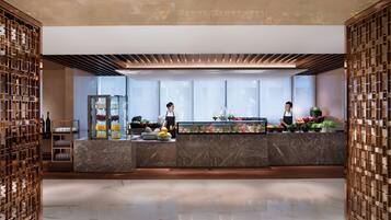 A modern reception area with marble counters, a glass display case, and wooden decor.