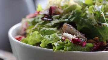 A bowl of salad with various greens and toppings.
