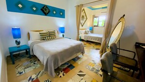 Une chambre à coucher avec un lit, deux tables de chevet, un miroir et un sol à motifs.