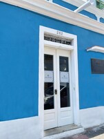Un edificio azul con una puerta blanca identificada con los números "262" y letreros que indican "casa sanches boutique hotel".