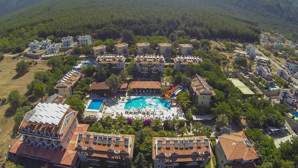 Luchtbeeld van een resort met meerdere gebouwen, een centraal gelegen zwembad en een glijbaan.