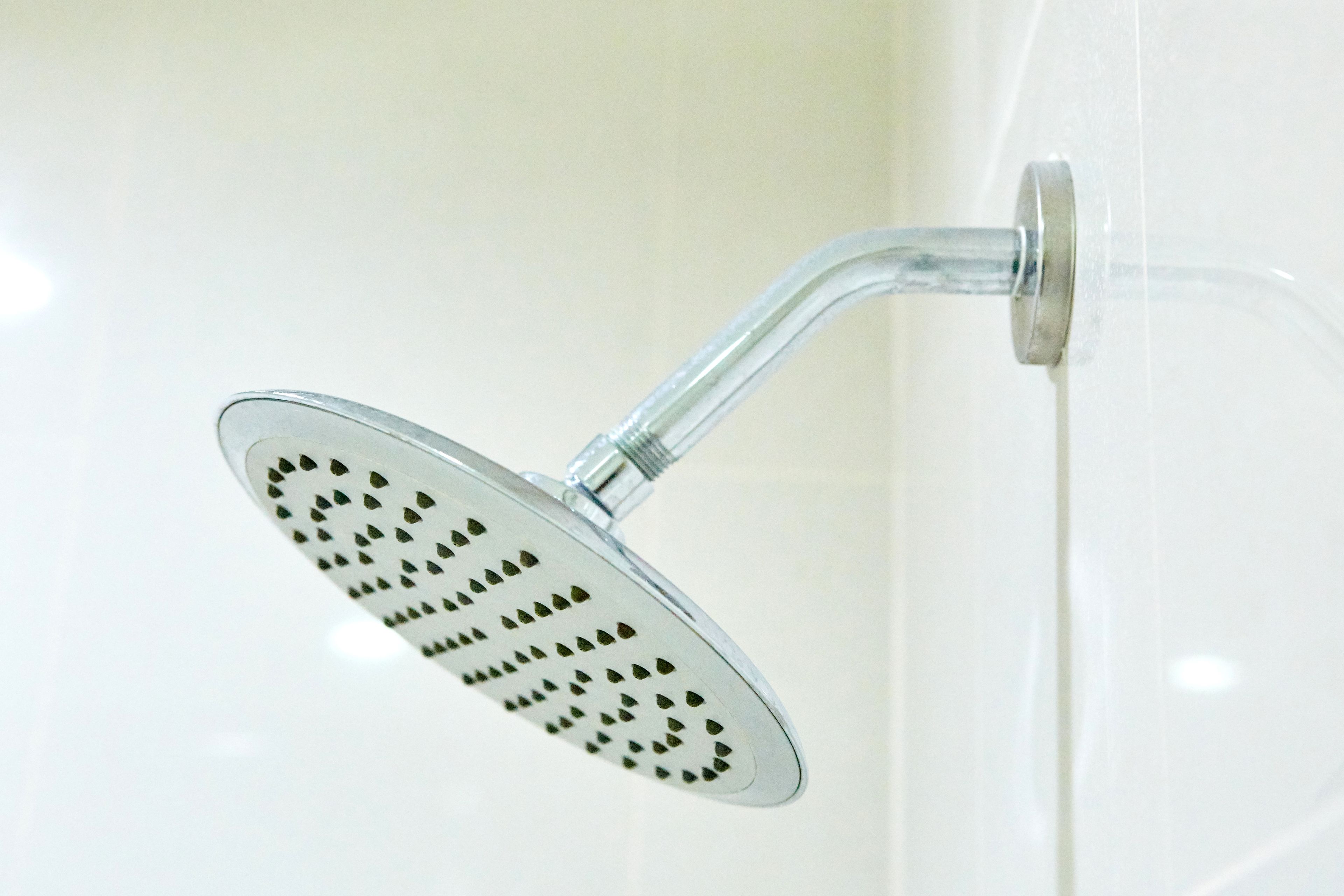 A showerhead with a curved design and a transparent water flow indicator.