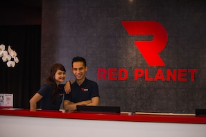 A reception desk with a sign reading "RED PLANET" and a logo.