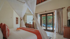 A bedroom with a bed, a red throw, and a canopy. - Parigata Villas Resort (Denpasar)