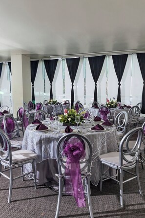 A banquet hall with round tables, chairs, and draped curtains. - Gamma Morelia Beló (Morelia)