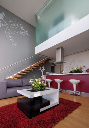 A modern interior with a staircase, a sofa, a coffee table, and a kitchen area. - Gamma Morelia Beló (Morelia)