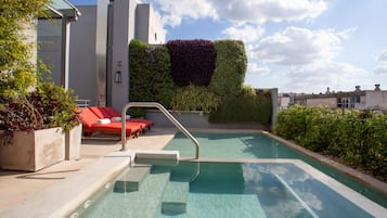 Una piscina al aire libre de temporada, sillones reclinables de piscina