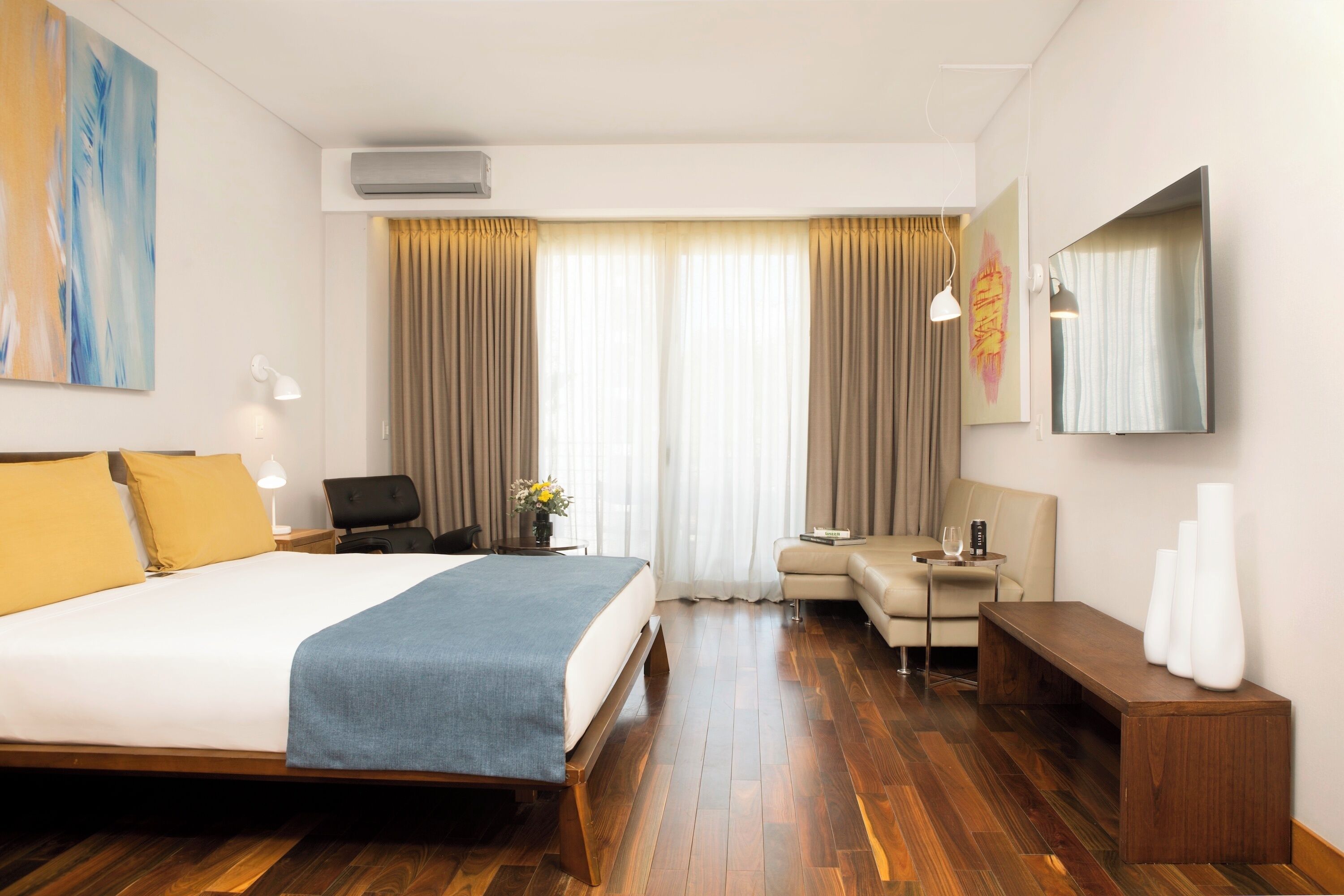 Een hotelkamer met een groot bed, een bureau, een bank en een televisie.