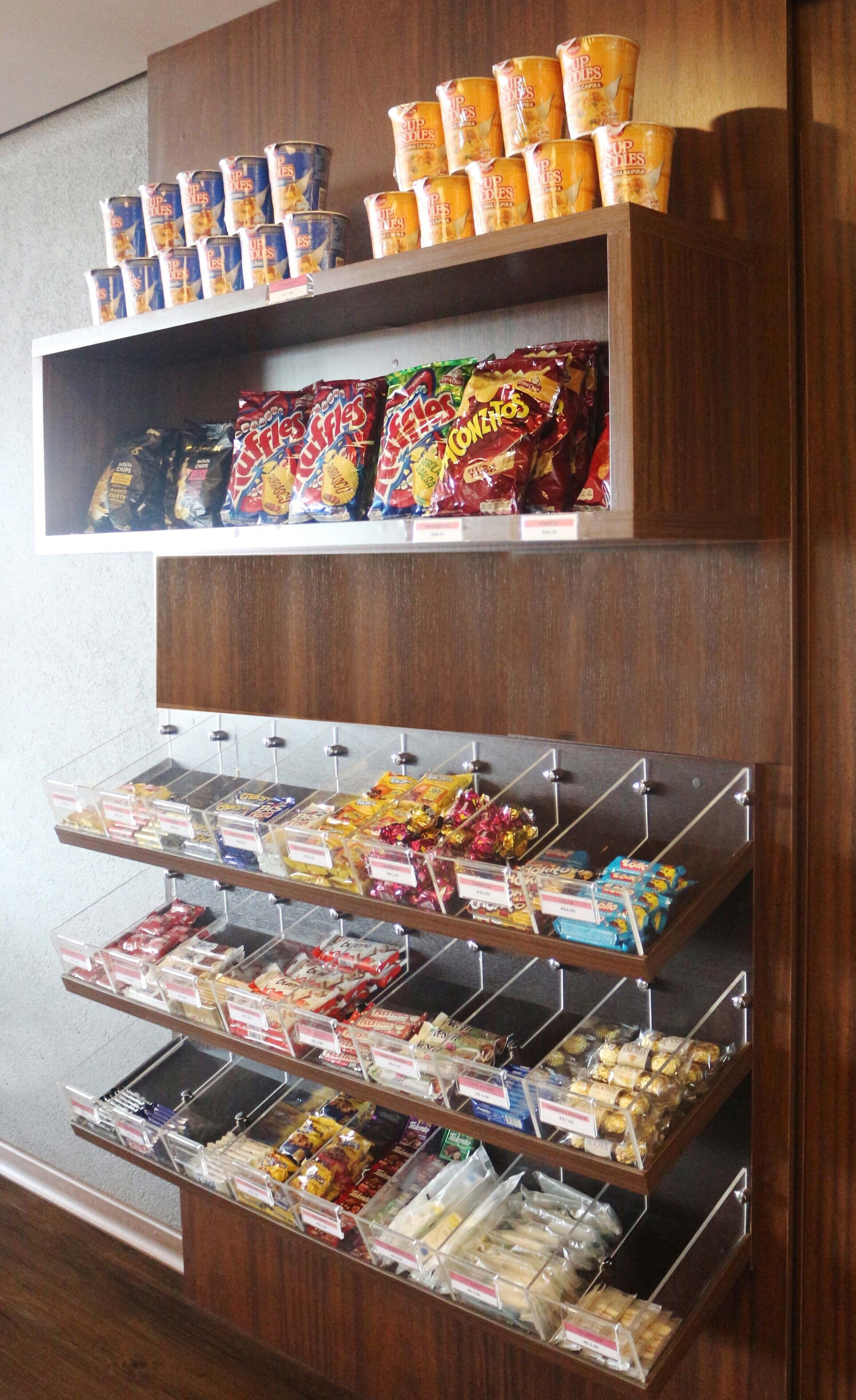 Exposição de lanches com diversos alimentos e bebidas embalados.