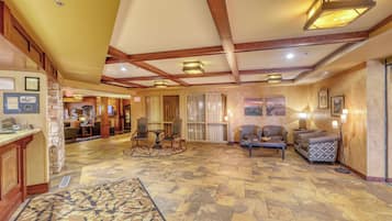 A spacious lobby with a high ceiling, wooden beams, and a patterned rug.