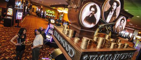 Een casino met gokautomaten, een groot geldbedrag in het zicht en een vloerbedekking.