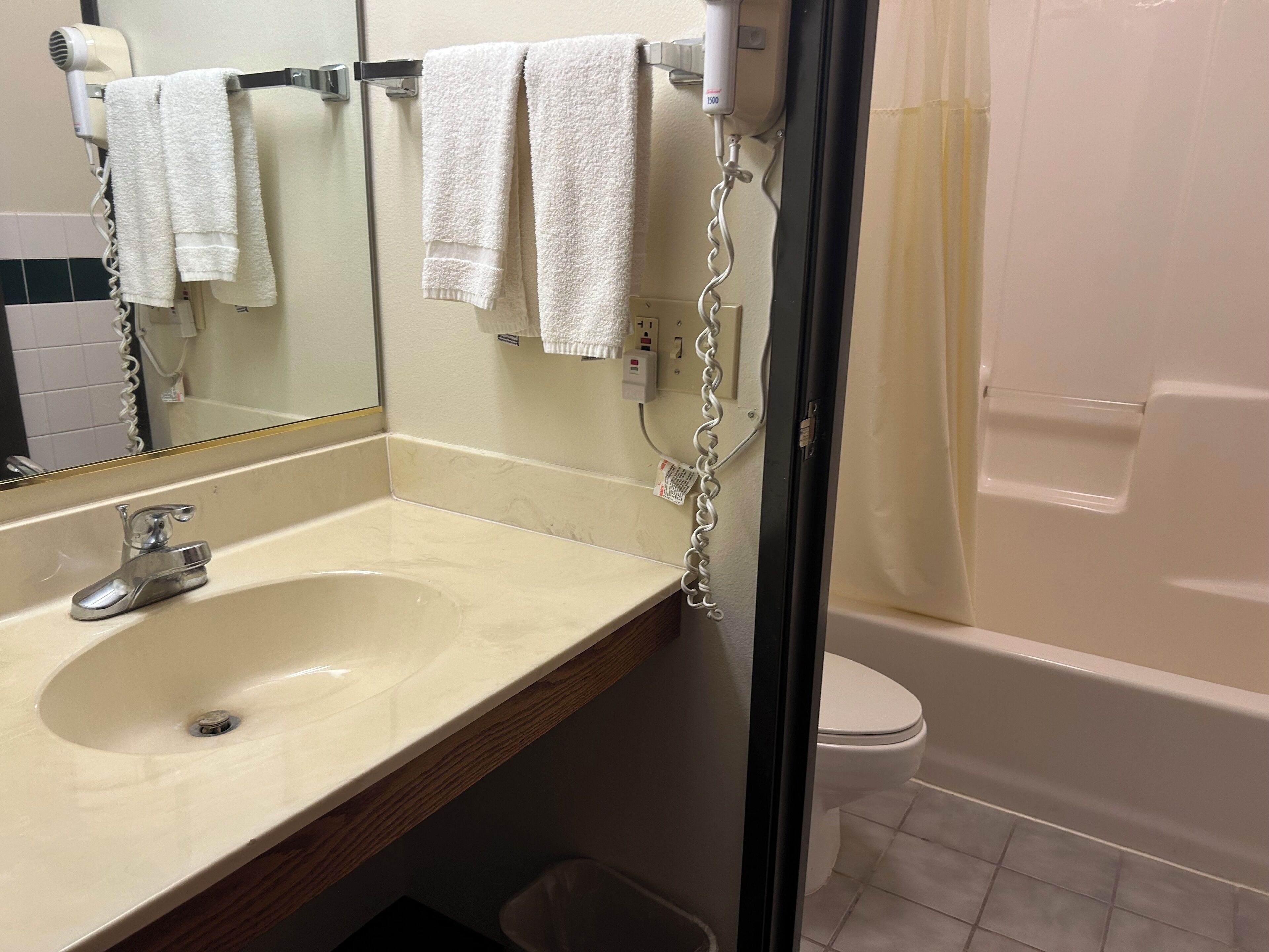A bathroom with a sink, mirror, and a toilet.