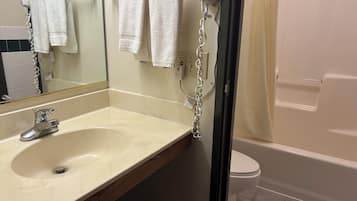 A bathroom with a sink, mirror, and a toilet.