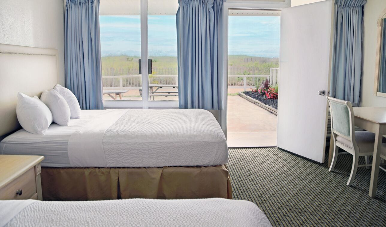 Habitación de hotel con cama, escritorio y vistas al exterior.