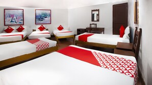 A hotel room with four single beds, each with red and white bedding, and a red and white patterned runner. There are two paintings on the wall, a wooden desk, and a mirror. - OYO Hotel Brazil,Guadalajara,Estadio Jalisco (Guadalajara)
