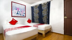 A room with two beds, each with a red and white patterned pillow, a wooden floor, and a painting of watermelons on the wall. - OYO Hotel Brazil,Guadalajara,Estadio Jalisco (Guadalajara)