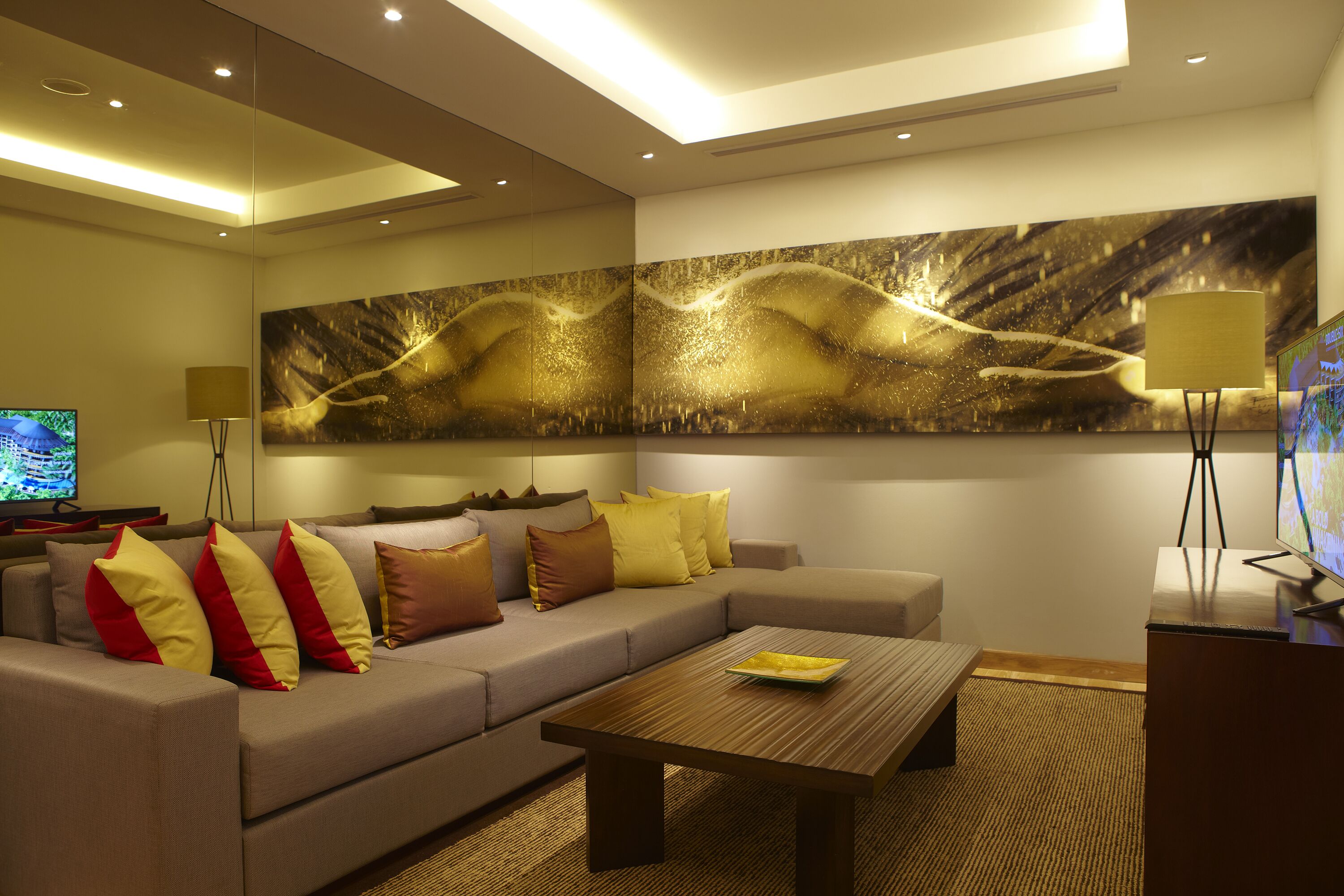 A modern living room with a sofa, coffee table, and a large abstract painting on the wall.