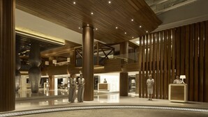 A spacious lobby with high ceilings, wooden paneling, and a central reception desk. - Double-Six Luxury Hotel (Seminyak)
