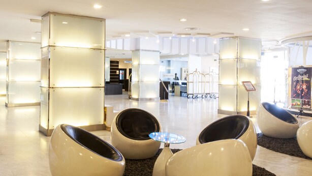 A modern lobby with a central seating area featuring egg-shaped chairs and a small table. - Borneo Royale Hotel (Tawau)
