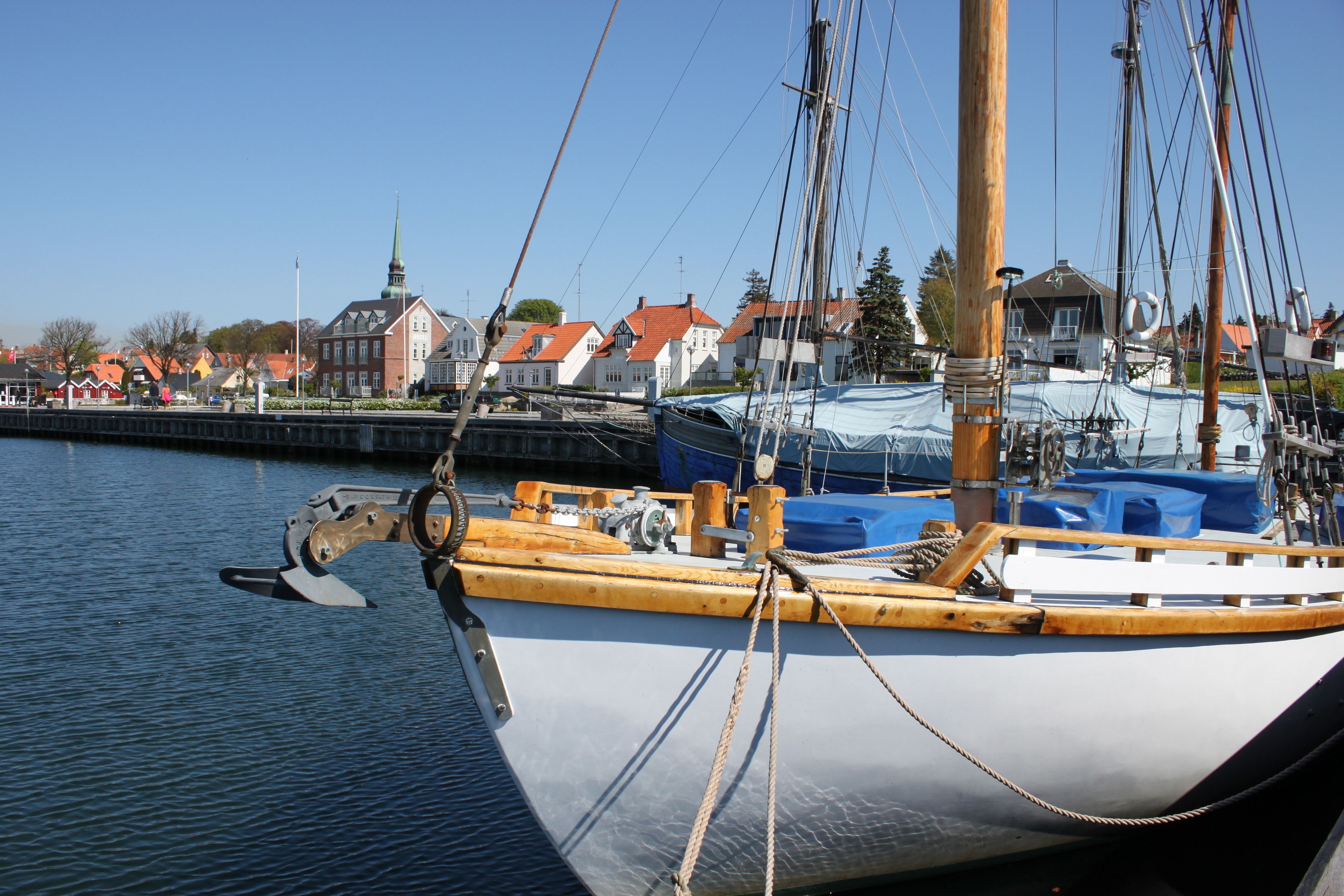 A boat docked at a harbor with a town in the background.