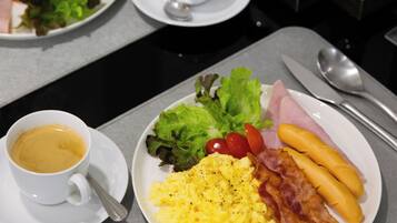 Bandeja de desayuno con huevos, tocino, jamón y salchichas.