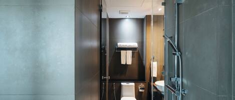A modern bathroom with a toilet, bidet, and shower.