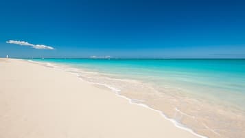 Nära stranden, vit sandstrand, solstolar och parasoller