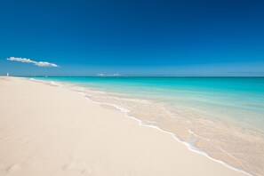 Ein Strand mit klarem türkisblauem Wasser und einem Sandstrand.