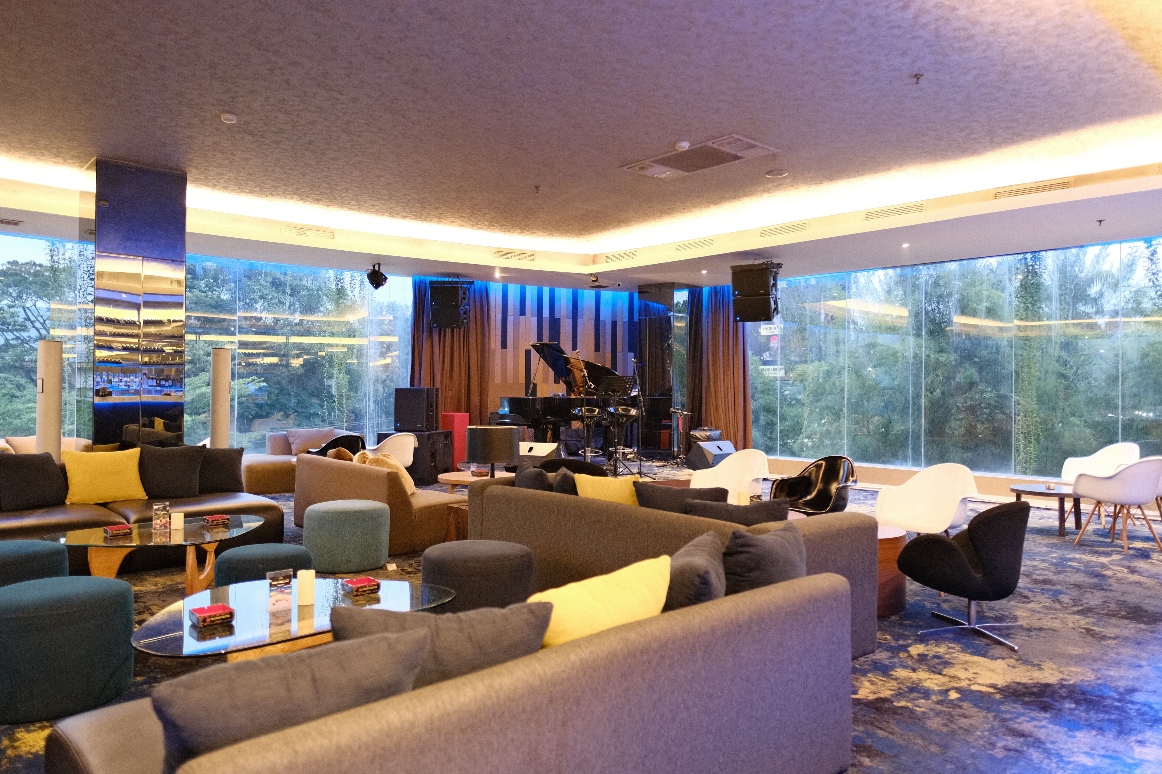 A modern living room with sofas, a coffee table, and a piano.
