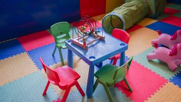 A play area with a table, chairs, and a toy.