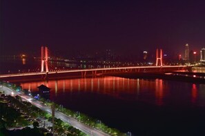 A nighttime view of a bridge with lights reflecting on the water.