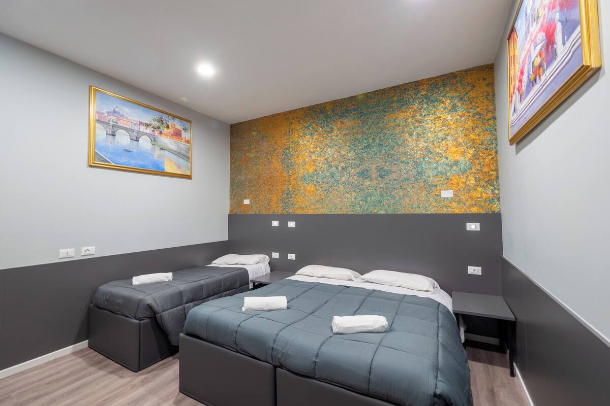 A hotel room with two beds, a large abstract painting on the wall, and a framed picture above the beds.