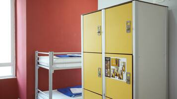 Een stapelbed met een blauwe matras en een gele kast met een poster erop.