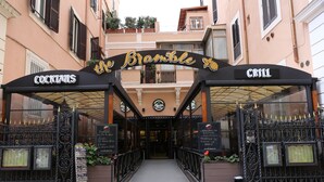 The entrance to 'The Bramble' with signs for 'COCKTAILS' and 'CRILL'. - Alessandro Palace & Bar - Hostel (Rome)
