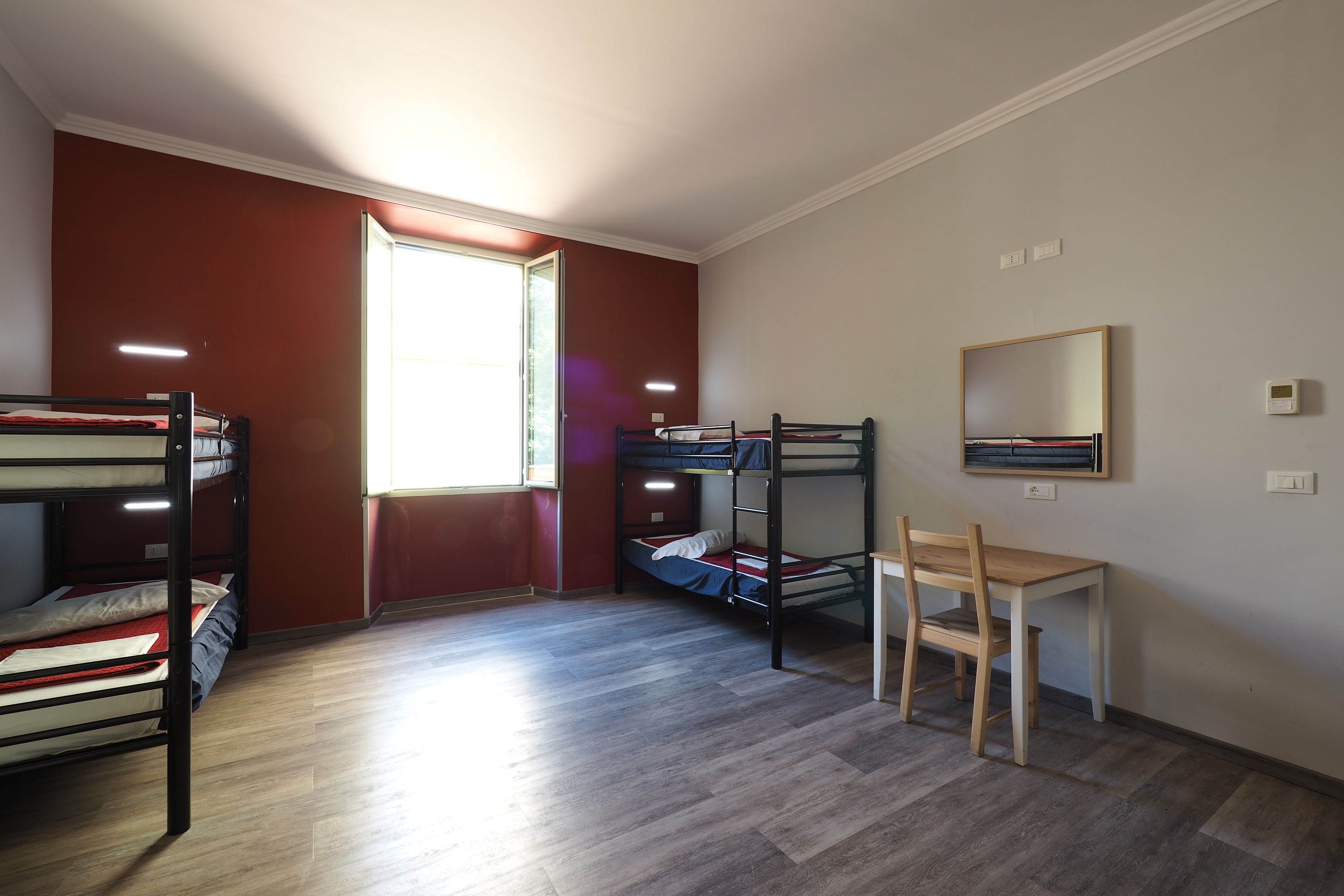 Una habitación con literas, un escritorio y una silla.