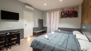 A hotel room with a large bed, a desk, and a TV. - Alessandro Palace & Bar - Hostel (Rome)