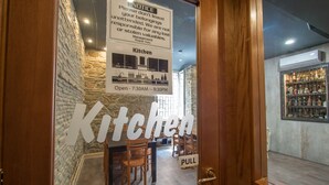A restaurant's entrance with a sign indicating the kitchen is open from 7:30 AM to 9:30 PM. - Alessandro Palace & Bar - Hostel (Rome)
