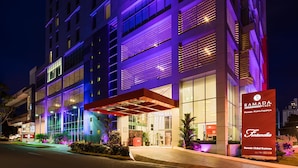 A multi-story hotel with a modern facade, large windows, and a prominent entrance with a covered area.