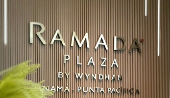 Señal para Ramada Plaza by Wyndham, con listones de madera verticales y letras metálicas.