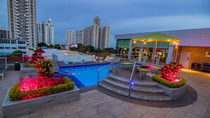 A rooftop pool area with a view of high-rise buildings in the background.