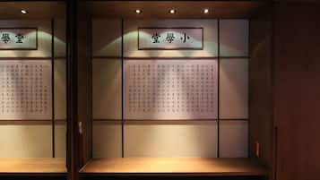 A traditional Japanese room with tatami flooring, a low wooden table, and calligraphy on the walls.