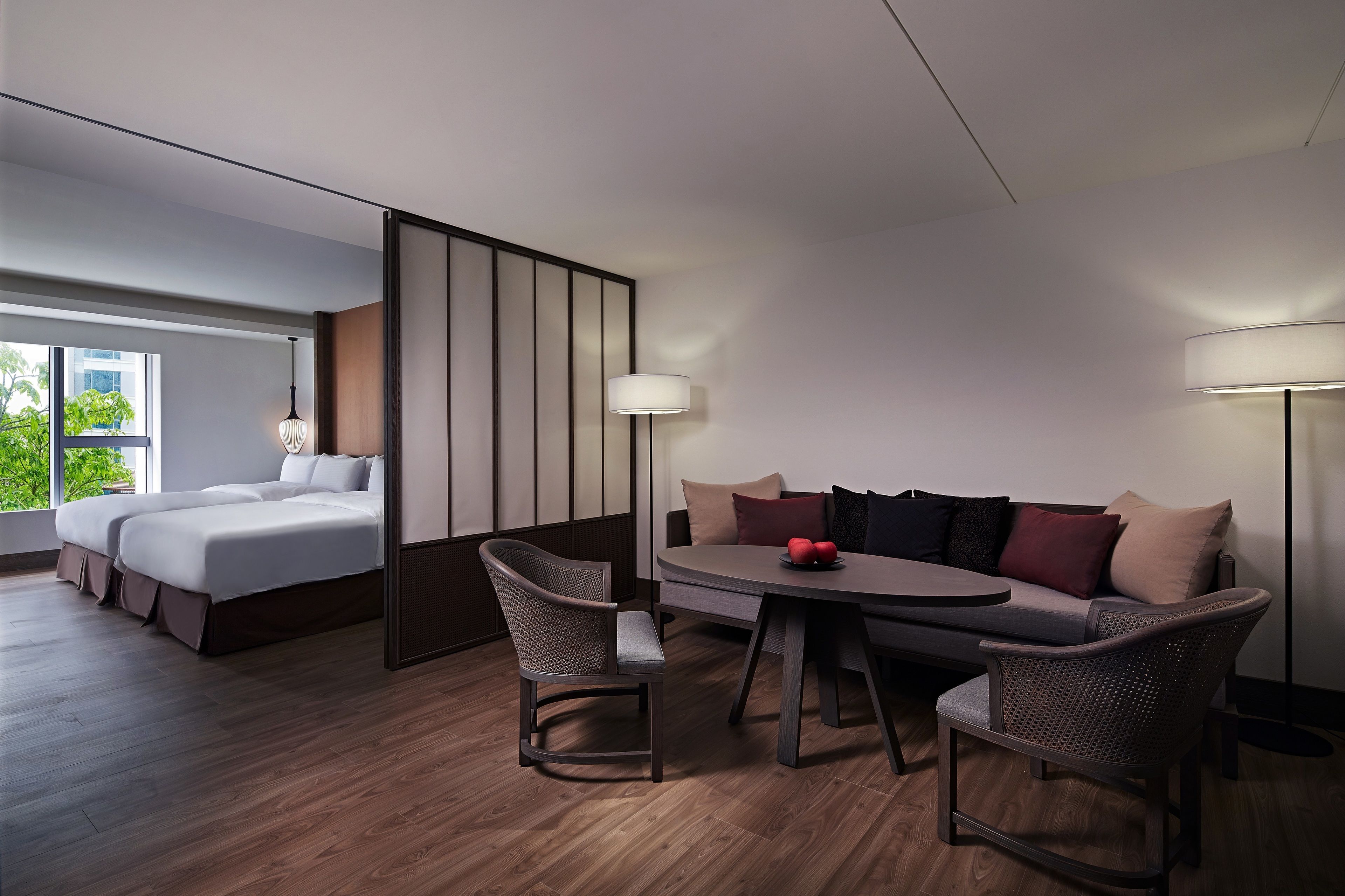 Una habitación de hotel moderna con una cama, un sofá, una mesa de comedor y una silla.