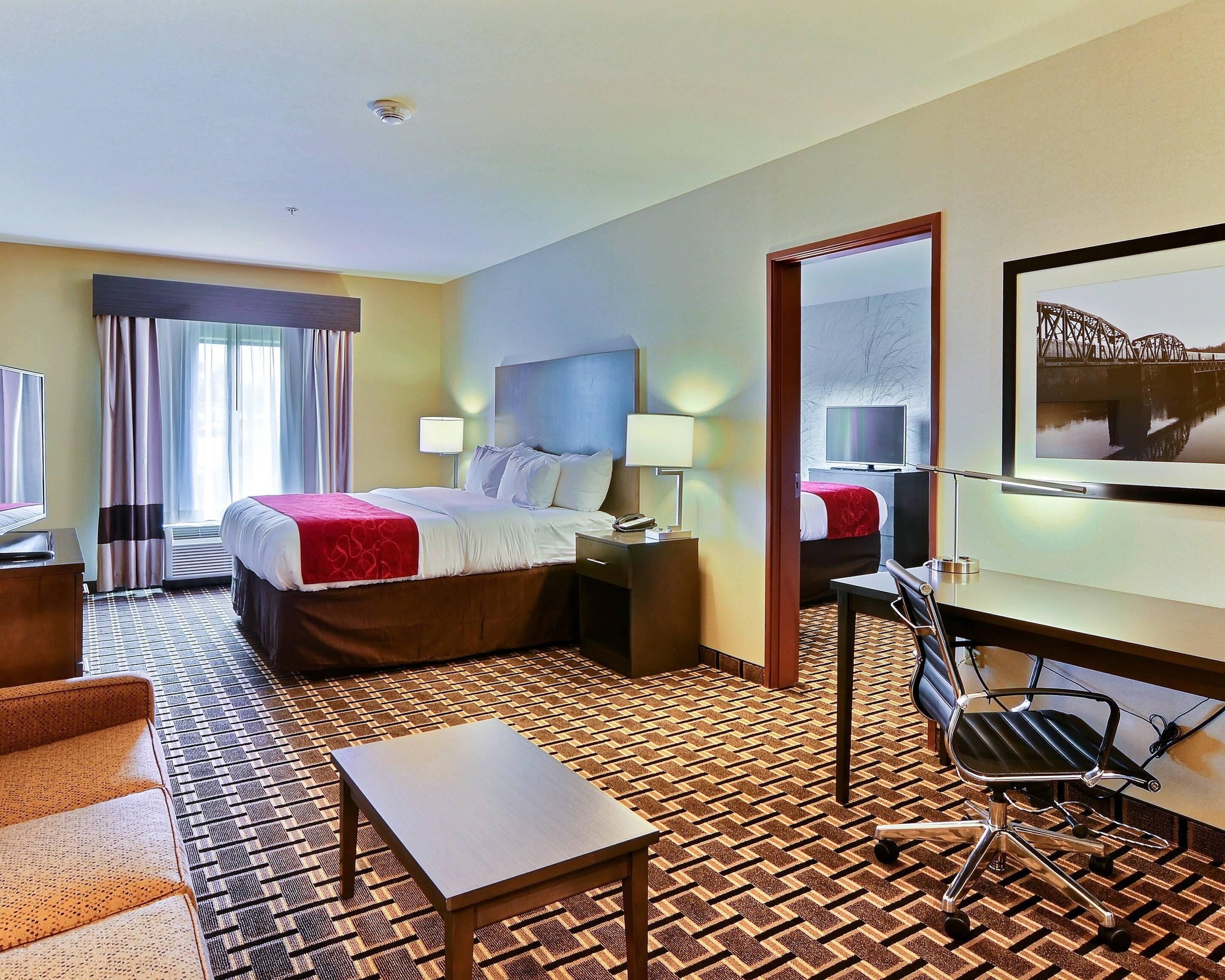 Una habitación de hotel con cama, escritorio, silla y televisión.