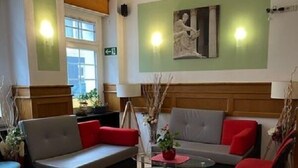 Un espace de détente moderne comprenant un canapé, des fauteuils et une petite table.