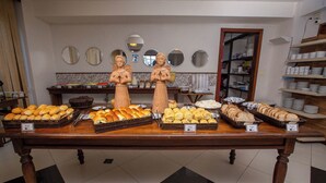 Een bakkerijdisplay met diverse gebakken producten en een spiegelwand.