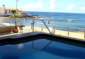 Une piscine avec vue sur l’océan et les bateaux.