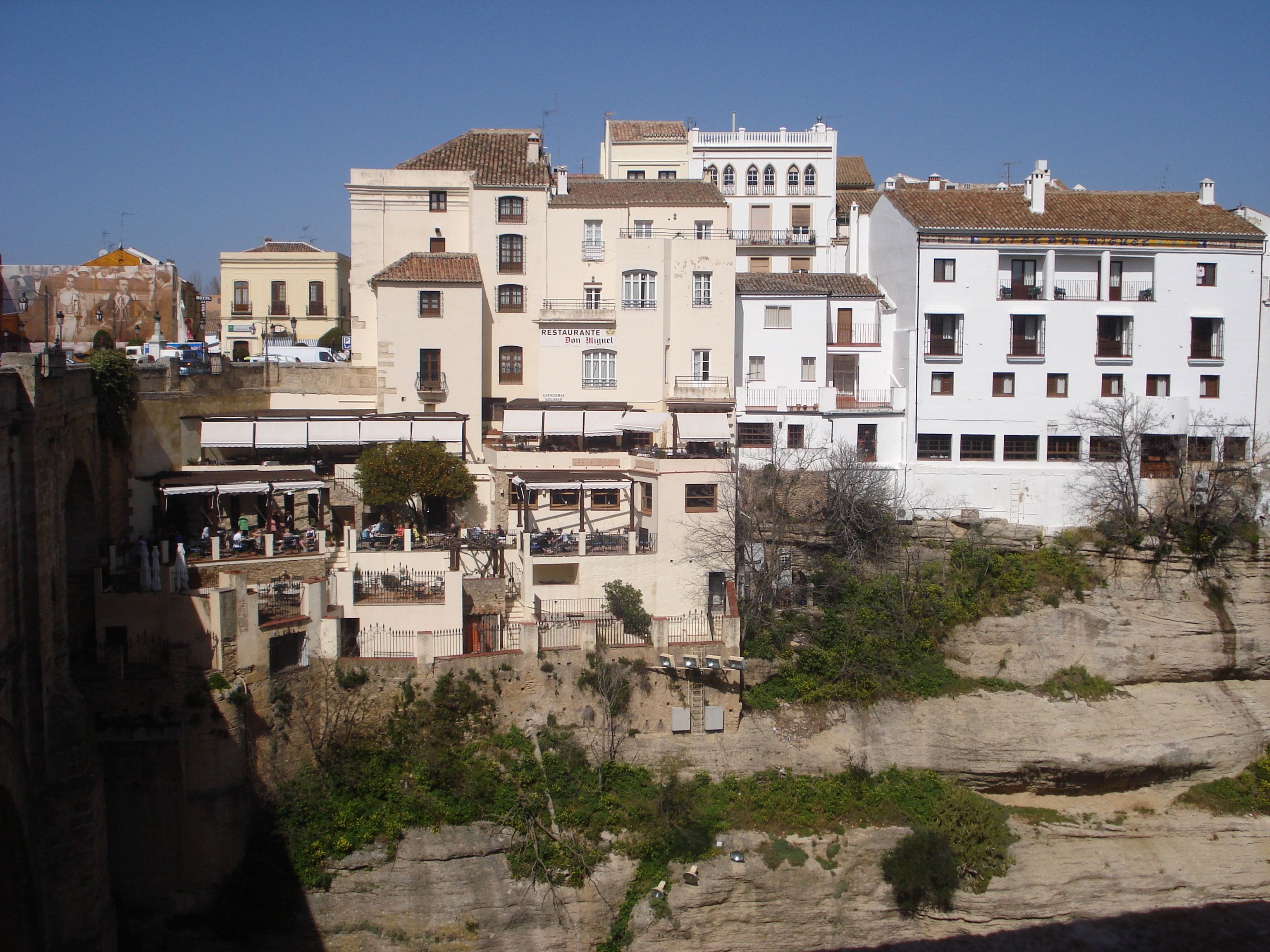 Un pueblo costero con edificios de diferentes alturas, algunos con balcones y terrazas.