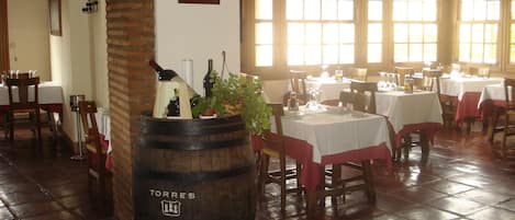 A restaurant interior with brick arches, wooden tables, and a barrel labeled "TORRES" in the center.