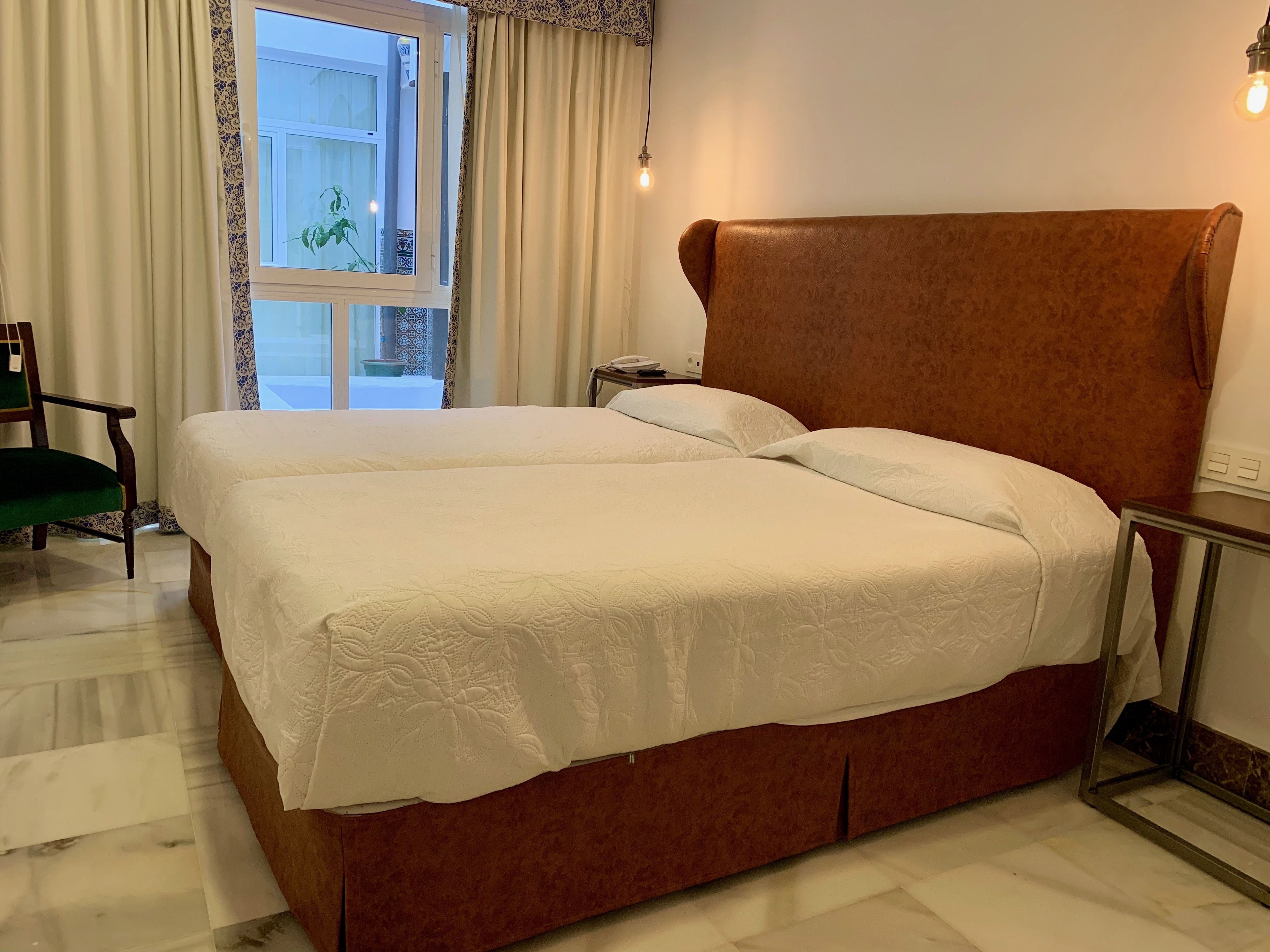 A double bed with a brown headboard in a hotel room.